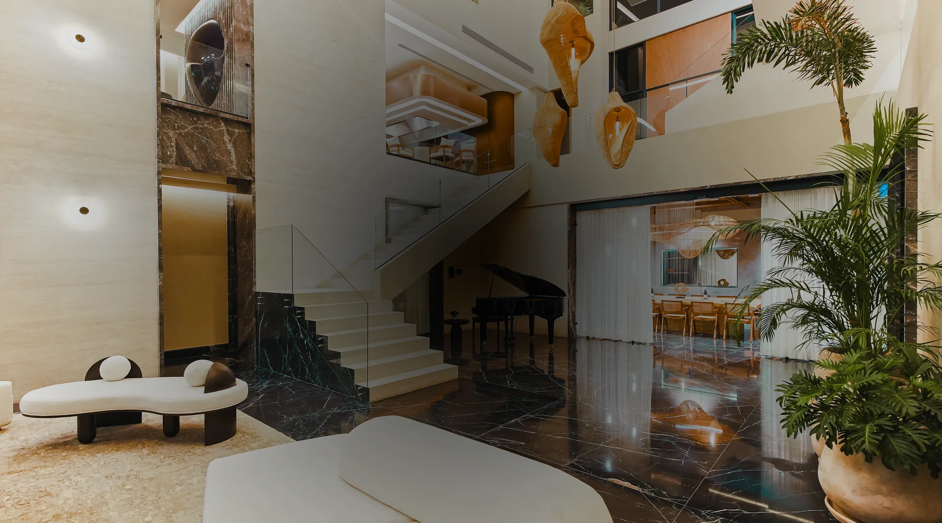 The villa’s marble atrium, sculptural lighting, staircase and piano