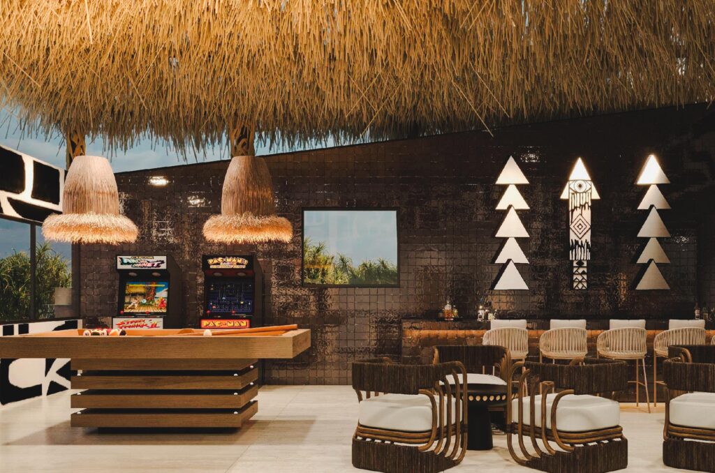 Luxury gaming area with chairs for sitting, snooker table, and gaming machines in it